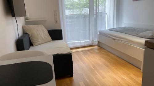 a bedroom with a bed and a chair and a window at Myroom Business Apartment Nähe Messe München in Munich