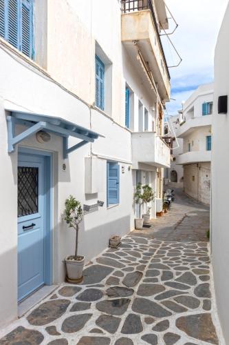 an alley with a blue door and potted plants at Aotés in Naxos Chora