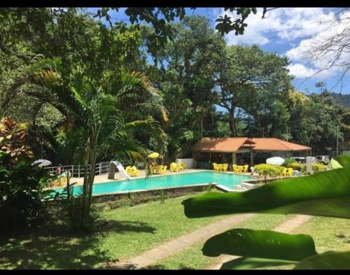 uma piscina num quintal com um resort em Pousada Estação Boca do Mato em Cachoeiras de Macacu