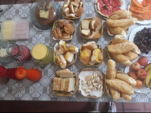 uma mesa com vários tipos diferentes de pastelarias em Pousada Estação Boca do Mato em Cachoeiras de Macacu