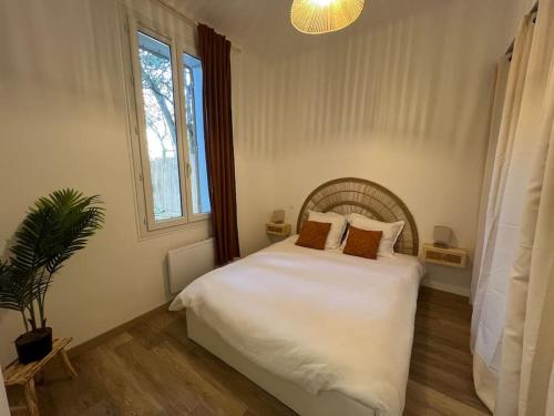 une chambre avec un lit blanc et une fenêtre dans l'établissement Très bel appartement neuf Avignon, à Avignon