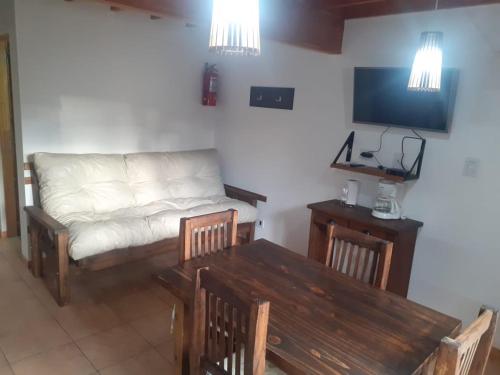 un soggiorno con divano e tavolo di Cabañas lo de Ani Casa 1 a San Carlos de Bariloche