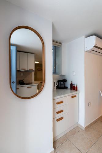 a kitchen with a mirror and white cabinets at Aotés in Naxos Chora