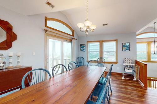 a dining room with a wooden table and chairs at House of the Rising Sun #5-W in Waves