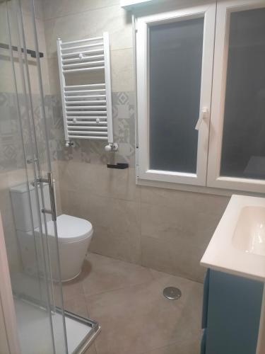 a bathroom with a toilet and a glass shower at PIso recién reformado y espacioso in Haro