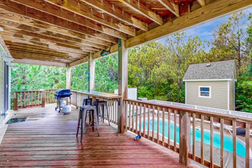 a wooden deck with a swimming pool on a house at House of the Rising Sun #5-W in Waves