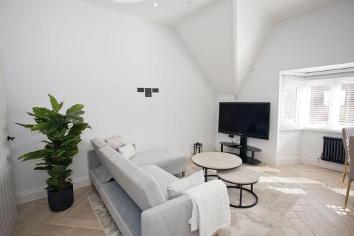 a living room with a couch and a tv at Ultra Stylish Apt set in an affluent location in Poole