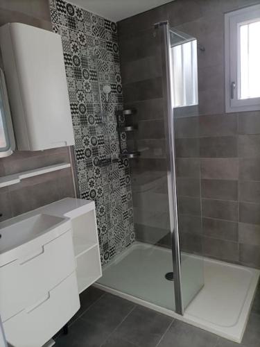 a bathroom with a shower with a glass door at L'Orée des Vignes in Chinon