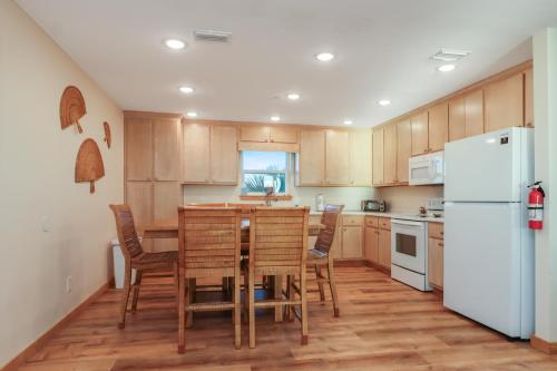 Una cocina con mesa y sillas y un refrigerador. en Holiday House A by Pristine Properties Vacation Rentals, en Mexico Beach
