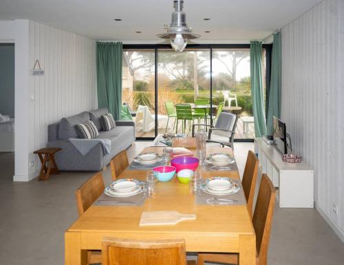 un salon avec une table et des chaises en bois dans l'établissement Petite dune, Port Blanc Vue Mer 20 m, à Penvénan