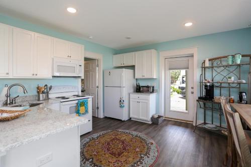 a kitchen with white appliances and blue walls at Beach View Lower by Pristine Properties Vacation Rentals in Mexico Beach
