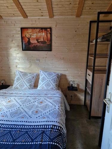 une chambre avec un lit dans un mur en bois dans l'établissement Chalet Edelweis, à Plombières-les-Bains