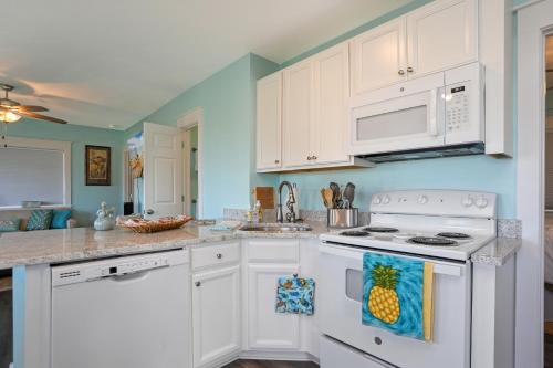 a kitchen with white cabinets and a white stove top oven at Beach View Lower by Pristine Properties Vacation Rentals in Mexico Beach
