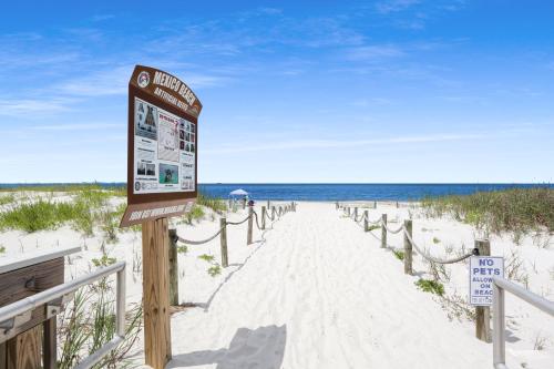 a sign on the beach next to the ocean at Beach View Lower by Pristine Properties Vacation Rentals in Mexico Beach