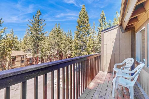 a balcony with two white chairs and trees at Lake Village Townhouse B in Zephyr Cove