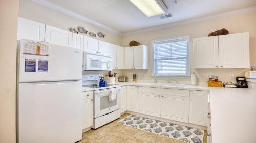 a white kitchen with white appliances and a window at 321 Willow Bend condo in North Myrtle Beach