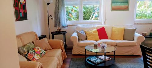 a living room with a couch and a table at Apartamento do jardim in Cascais