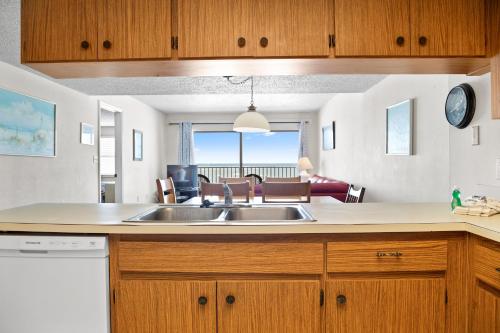 a kitchen with a sink and a living room at 310 Beach Place Condos in St. Pete Beach