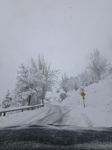 a road covered in snow with a sign next to it at Hostal Boutique CUMBRES in Farellones