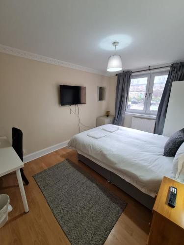 ein Schlafzimmer mit einem großen Bett und einem TV in der Unterkunft Arthur St Rooms in Edinburgh