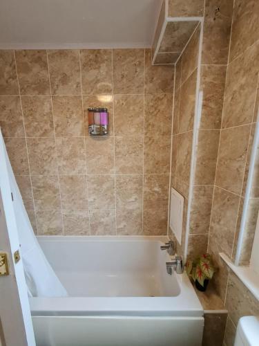 ein Badezimmer mit einer Badewanne und einem Waschbecken in der Unterkunft Arthur St Rooms in Edinburgh