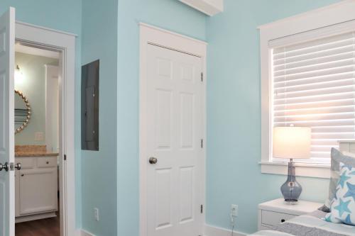 a bedroom with blue walls and a white door at Beach View Upper by Pristine Properties Vacation Rentals in Mexico Beach