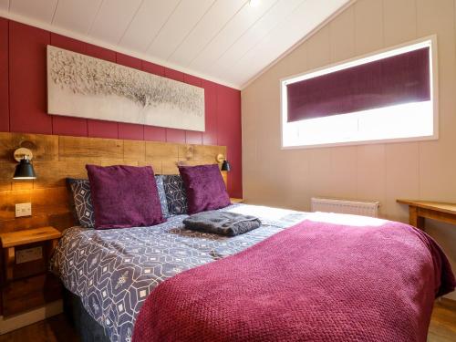 een slaapkamer met een groot bed met paarse lakens bij Oak in Swadlincote