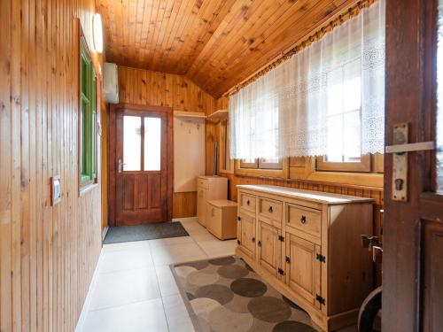 a kitchen with wooden walls and a wooden ceiling at Drevenička v Durčinej - Magdaléna in Ďurčiná