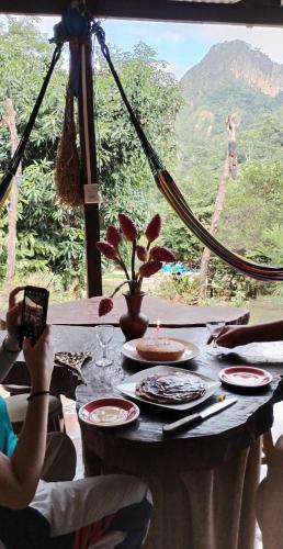 a person taking a picture of a table with a view at Mirador Jungle El Macuti in Rurrenabaque