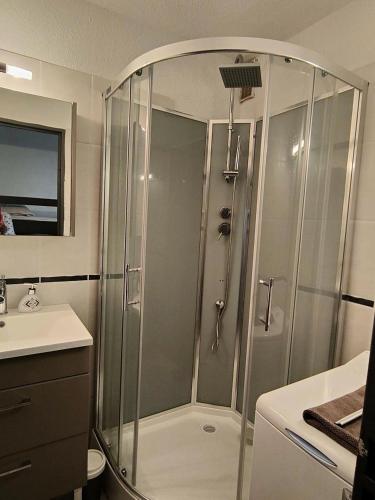une douche avec une porte vitrée dans une salle de bain dans l'établissement Résidence Pointe Vermeille - 2 Pièces pour 4 Personnes 321, au Barcarès
