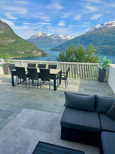 a patio with a couch and a table and chairs at Leilighet med fantastisk utsikt in Stryn