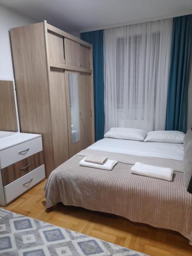 Un dormitorio con una cama y un tocador con toallas. en Apartman Dragon Kg en Kragujevac