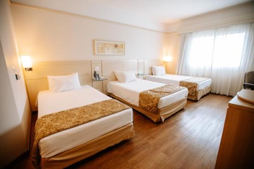 Cette chambre comprend 2 lits et une fenêtre. dans l'établissement Comfort Suites Londrina, à Londrina