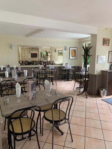 a dining room with tables and chairs and a kitchen at chez stephane in Pontcarré