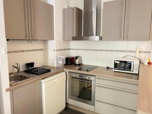 une cuisine avec un évier et un micro-ondes dans l'établissement Cosy F2 free parking 5 min metro near Seine, à Boulogne-Billancourt