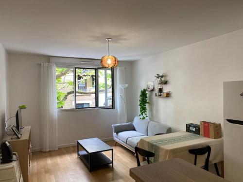 un salon avec un canapé et une table dans l'établissement Cosy F2 free parking 5 min metro near Seine, à Boulogne-Billancourt