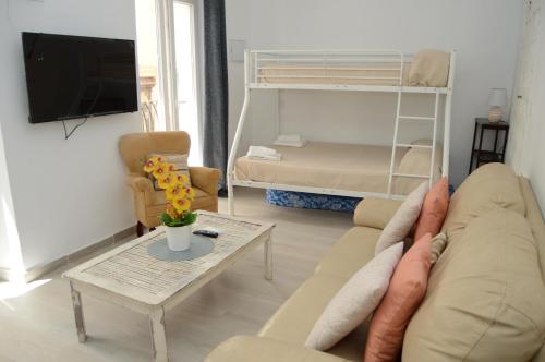 ein Wohnzimmer mit einem Sofa und einem Tisch in der Unterkunft Apartamentos Cuna 21 in Sevilla