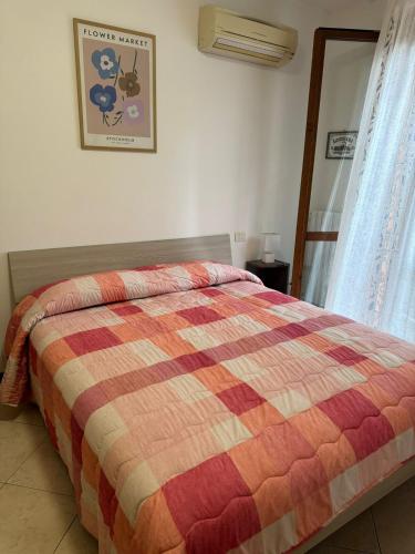 um quarto com uma cama com uma colcha colorida em A Casa San Pietro - bilocale centro storico - Cyclist-friendly em Castel San Pietro Terme