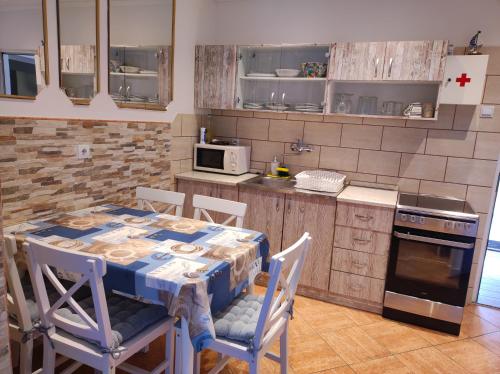 y cocina con mesa, sillas y fogones. en M&R apartmani Rovinj, en Rovinj
