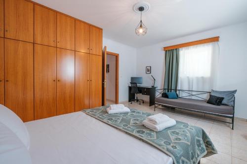 a bedroom with a bed and a couch and a desk at Soul V. House in Kos