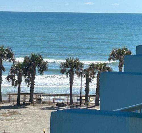 a view of a beach with palm trees and the ocean at Luxury Beach Condo with Pool and Tiki Bar! in Daytona Beach
