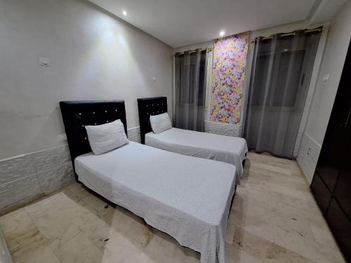 2 camas en una habitación con sábanas blancas en Corniche Casablanca en Casablanca