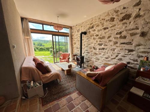 uma sala de estar com um sofá e uma parede de pedra em Les Chaumes en Morvan 