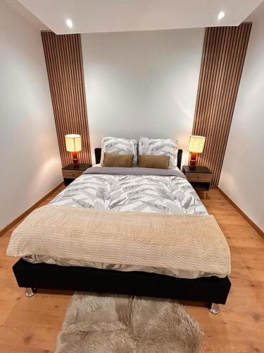 une chambre avec un grand lit avec deux lampes dans l'établissement Bel appartement, aux Mureaux