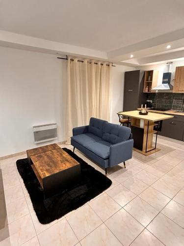 un salon avec un canapé bleu et une table dans l'établissement Bel appartement, aux Mureaux