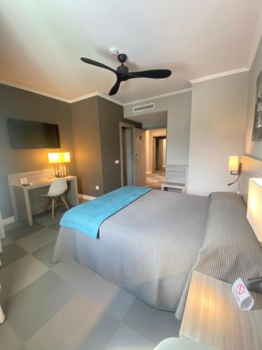a bedroom with a bed and a ceiling fan at Hotel Combarro in Combarro