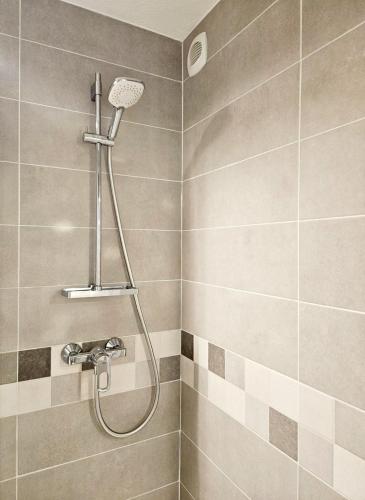 une douche avec pommeau de douche dans une salle de bain dans l'établissement Studio, Terrasse et piscine, Proche centre et plages, au Cap d'Agde