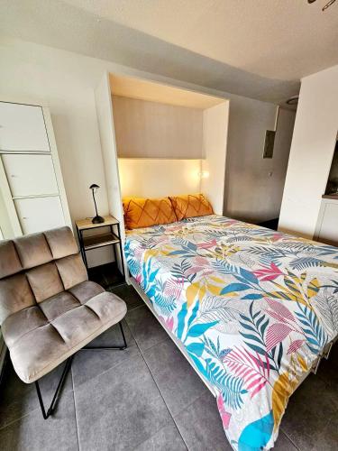 une chambre avec un grand lit et une chaise dans l'établissement Studio, Terrasse et piscine, Proche centre et plages, au Cap d'Agde