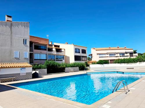 - une piscine en face de certains bâtiments dans l'établissement Studio, Terrasse et piscine, Proche centre et plages, au Cap d'Agde