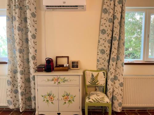 a room with a dresser and a chair and a window at The Rose Farm, mini parties, accommodation, pool, playground, bbq in Ciolpani